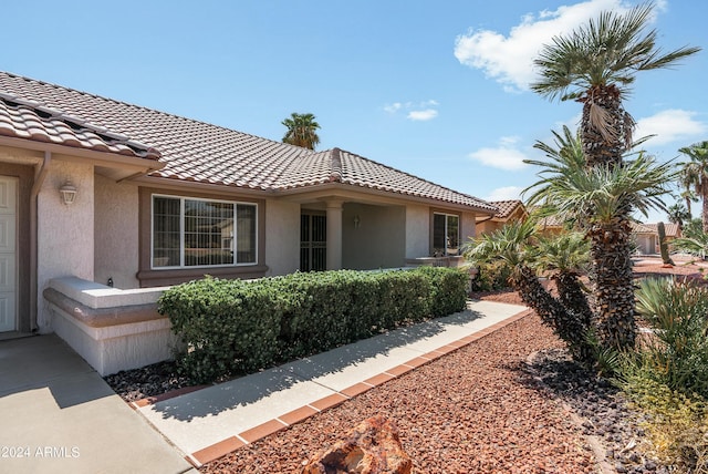 view of property exterior featuring a tile roof and stucco siding