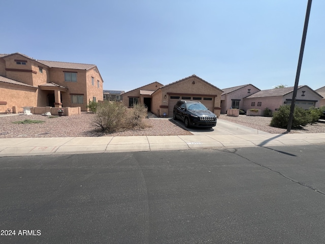 view of front facade featuring concrete driveway, a tiled roof, and an attached garage