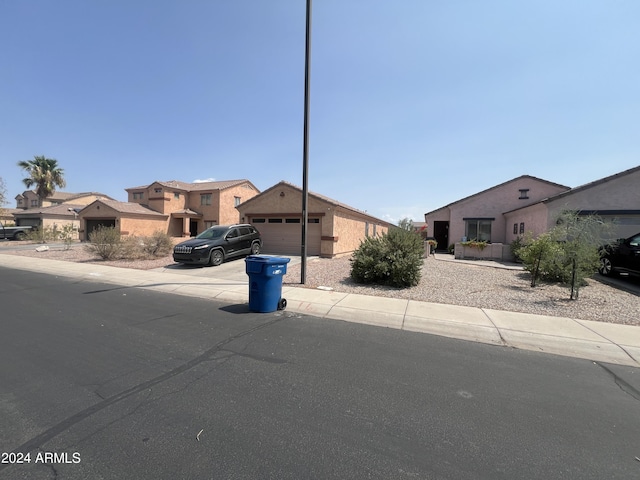 view of front of property with a residential view, driveway, and a garage