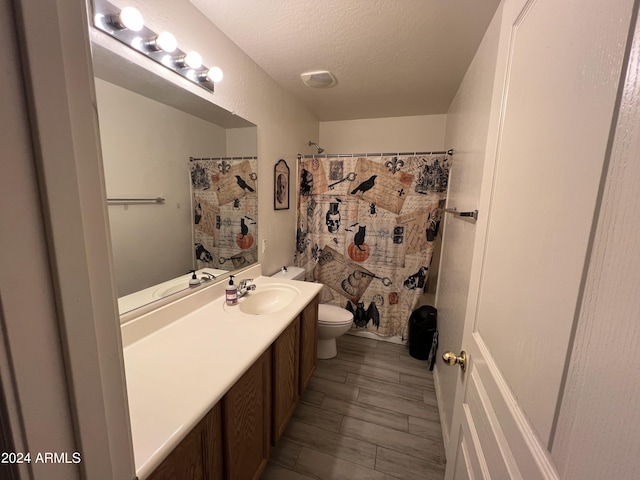 full bath featuring a textured ceiling, toilet, vanity, and a shower with curtain