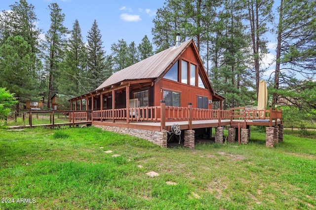 view of home's exterior with metal roof, a lawn, and a deck