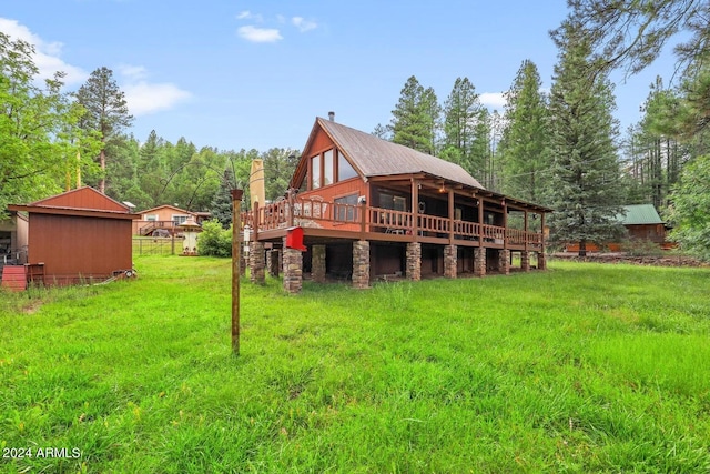 rear view of house with a deck and a yard