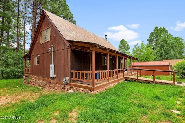 rear view of house featuring a yard