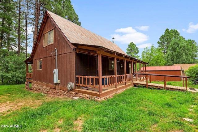 view of side of property featuring a lawn and metal roof