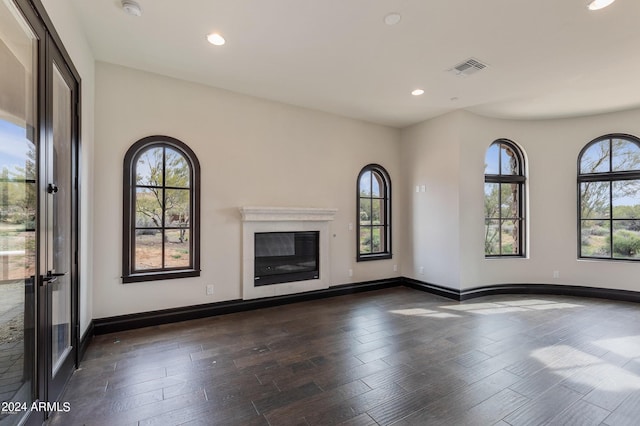 7254 E Sonoran Trl, Scottsdale, AZ 85266 - unfurnished living room featuring plenty of natural light, dark wood-type flooring, recessed lighting, and a glass covered fireplace