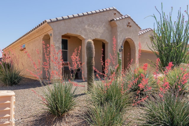 27418 W Mohawk Ln, Buckeye, AZ 85396 - view of property exterior with an attached garage, a tile roof, and stucco siding
