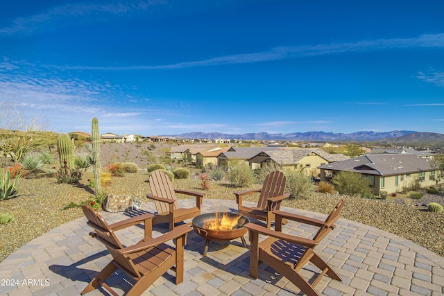 view of patio with a mountain view and an outdoor fire pit