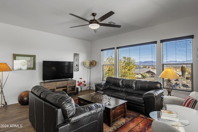 living room with ceiling fan and dark wood-type flooring