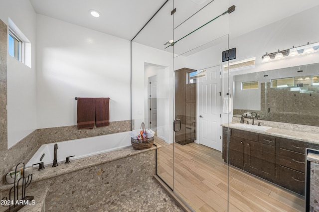 bathroom with hardwood / wood-style floors, vanity, and independent shower and bath