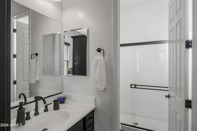 bathroom featuring vanity and an enclosed shower