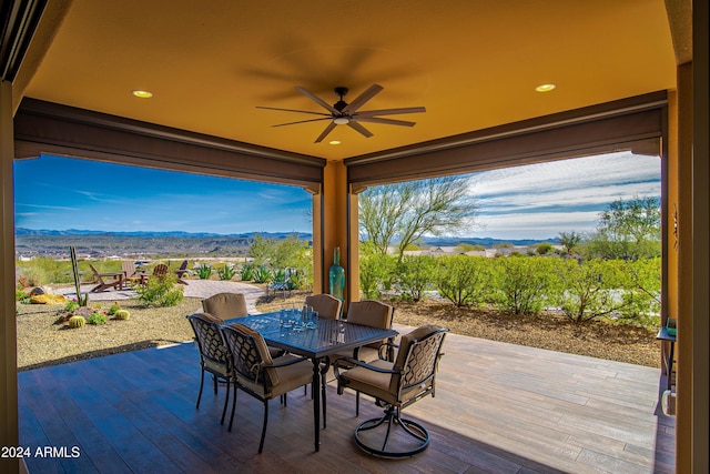 view of patio with ceiling fan and a deck with mountain view