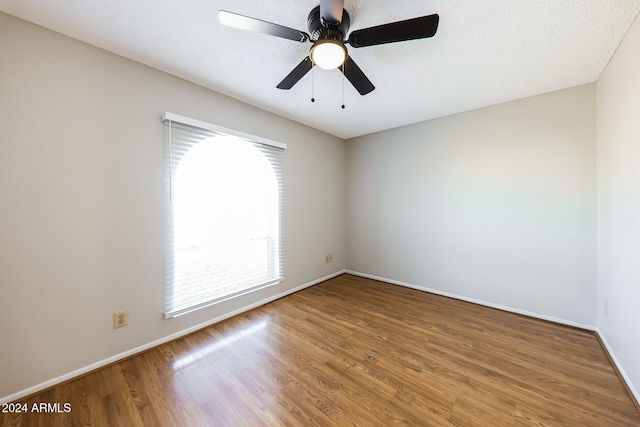 empty room with ceiling fan, a textured ceiling, and hardwood / wood-style flooring