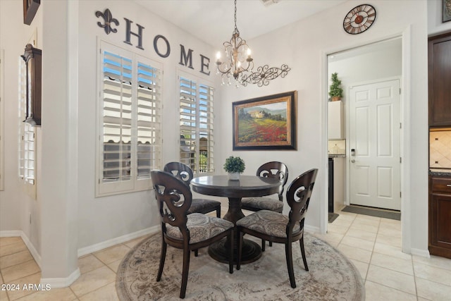 tiled dining room featuring an inviting chandelier