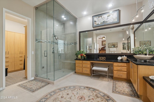 bathroom with tile patterned flooring, ceiling fan, walk in shower, and vanity