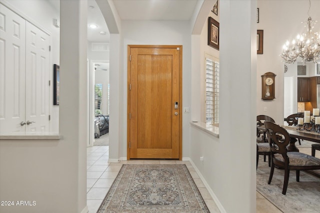 tiled foyer entrance featuring a notable chandelier