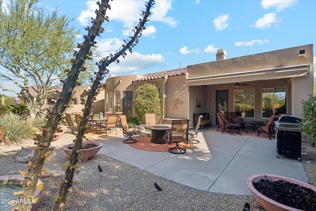 view of patio / terrace with a fire pit, ceiling fan, and a grill