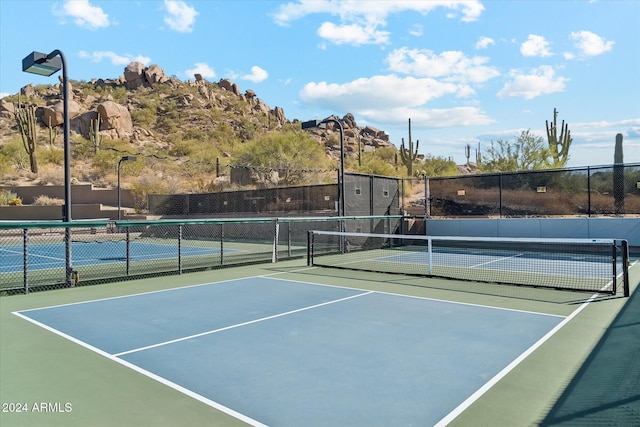 view of tennis court with basketball hoop