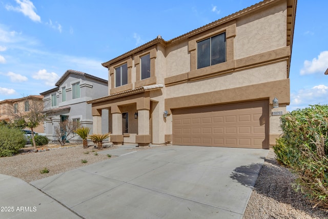 view of front of house with a garage, concrete driveway, a tile roof, and stucco siding