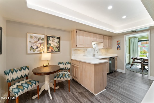 kitchen with backsplash, light brown cabinets, dark wood finished floors, dishwasher, and a raised ceiling