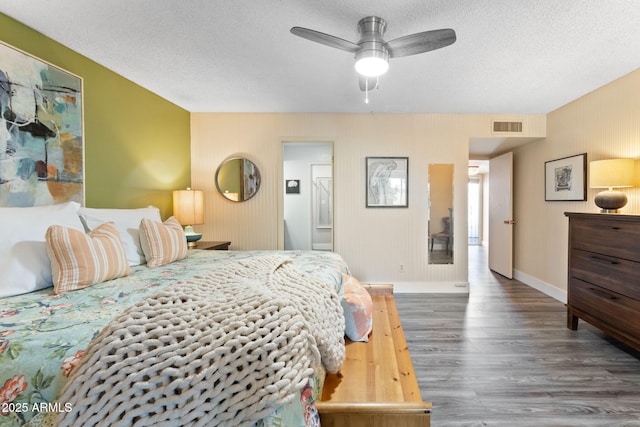 bedroom featuring a ceiling fan, baseboards, wood finished floors, visible vents, and a textured ceiling