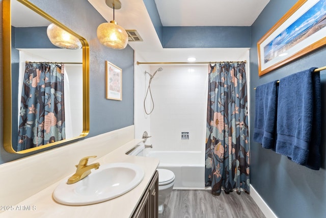 full bath with visible vents, toilet, wood finished floors, shower / tub combo, and vanity