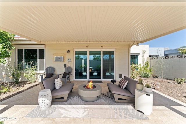 view of patio with an outdoor living space with a fire pit and fence