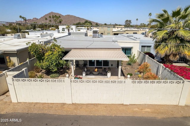 view of front of home featuring a mountain view, a patio, and a fenced backyard