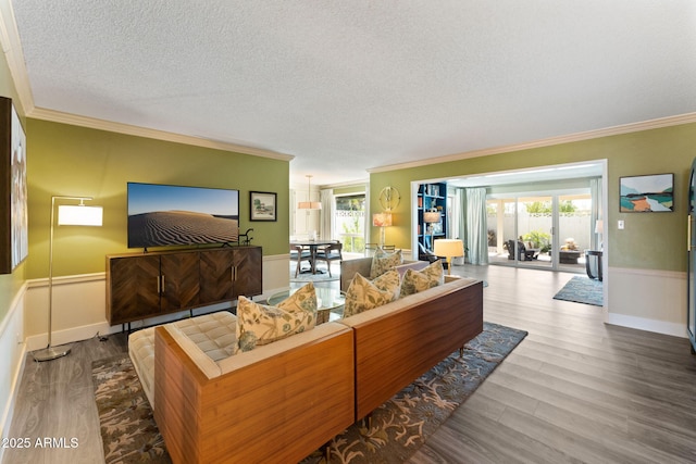 living room with crown molding, plenty of natural light, wood finished floors, and a textured ceiling