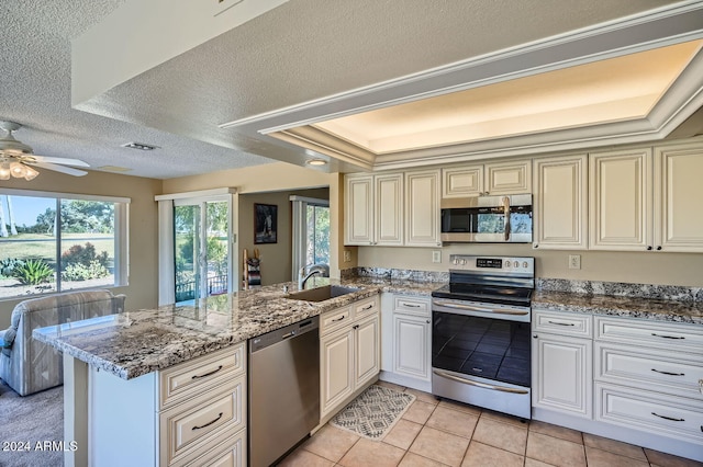 kitchen featuring kitchen peninsula, a textured ceiling, stainless steel appliances, and sink