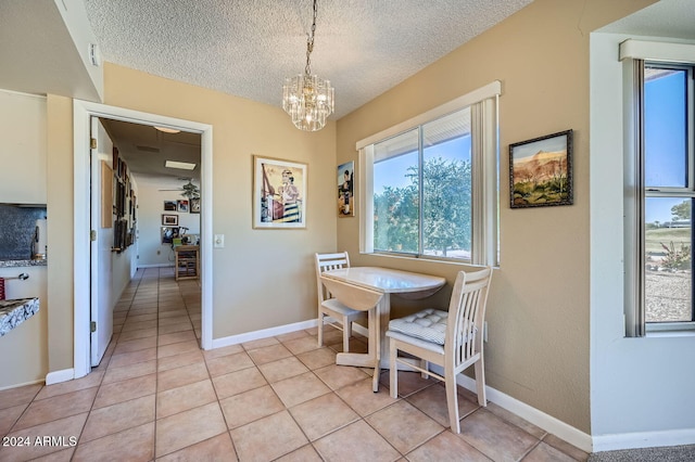 dining space with plenty of natural light, light tile patterned floors, a textured ceiling, and ceiling fan with notable chandelier