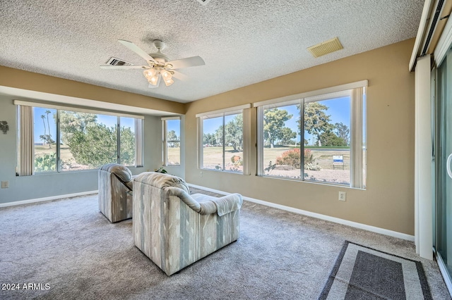 carpeted living room featuring a textured ceiling and ceiling fan