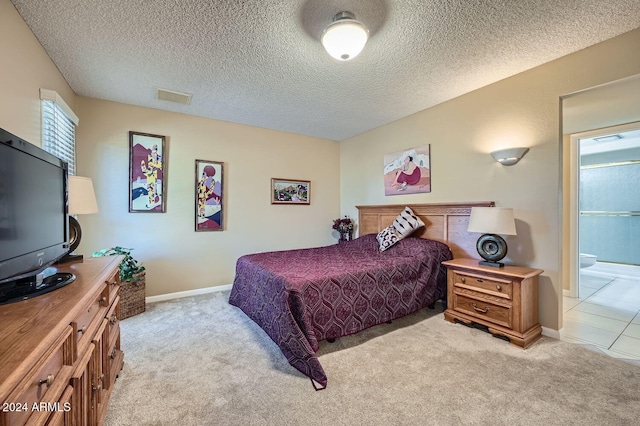 bedroom featuring light carpet, a textured ceiling, and connected bathroom