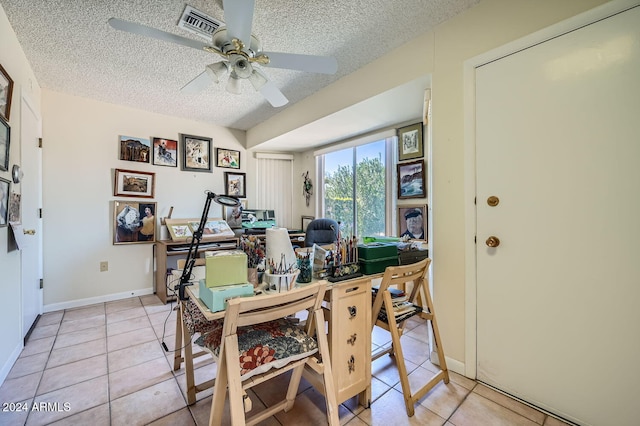 dining space featuring light tile patterned floors, a textured ceiling, and ceiling fan