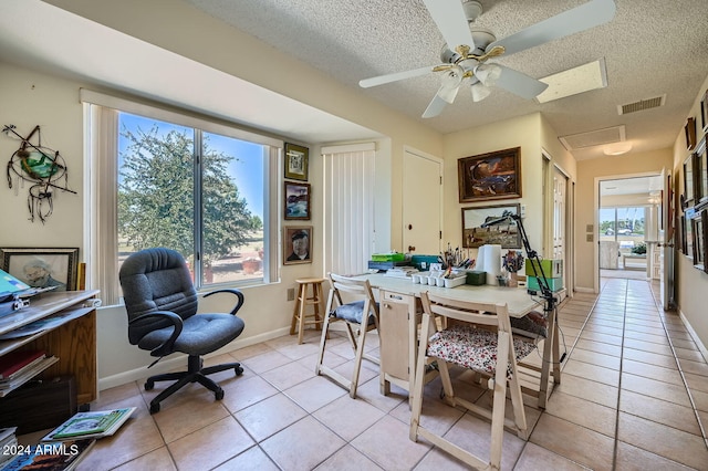 tiled dining room featuring ceiling fan, a textured ceiling, and a wealth of natural light