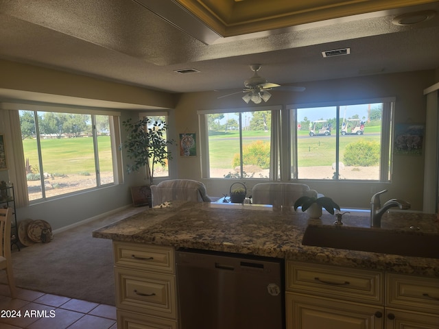 kitchen with sink, stainless steel dishwasher, ceiling fan, a textured ceiling, and light colored carpet