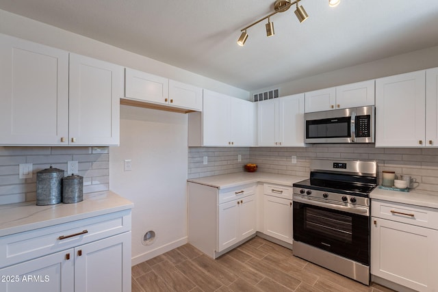 1466 E Nielson Ave, Mesa, AZ 85204 - kitchen with appliances with stainless steel finishes, white cabinetry, decorative backsplash, and light wood-type flooring