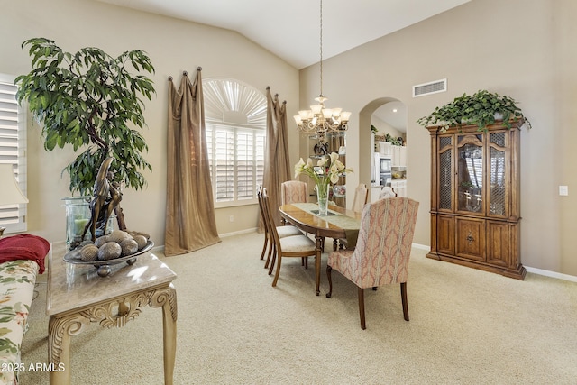 carpeted dining room with vaulted ceiling and a chandelier