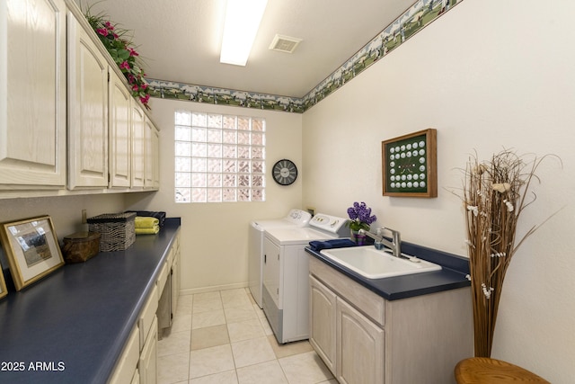 laundry area featuring sink, washer and clothes dryer, light tile patterned flooring, and cabinets