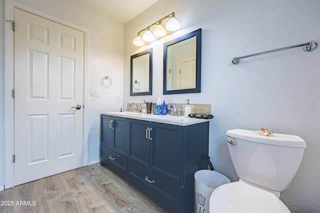 bathroom with vanity, toilet, and hardwood / wood-style floors