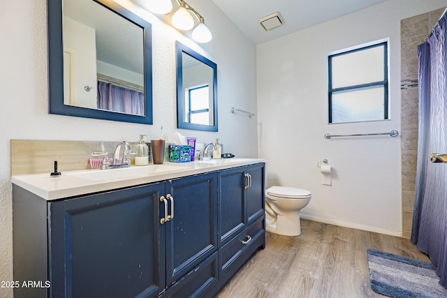 bathroom featuring hardwood / wood-style flooring, decorative backsplash, toilet, and vanity