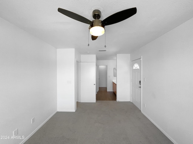 spare room with ceiling fan and carpet