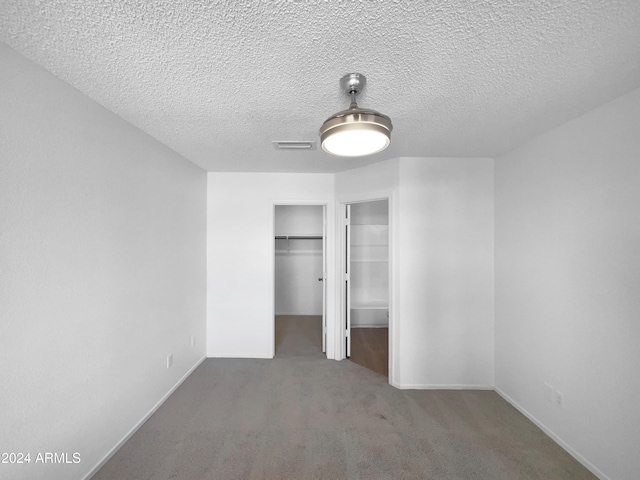 unfurnished bedroom featuring carpet flooring and a textured ceiling