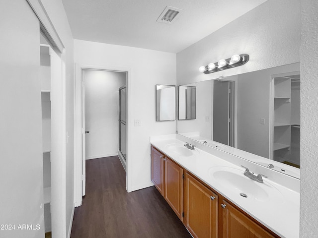 bathroom with hardwood / wood-style floors, vanity, and walk in shower