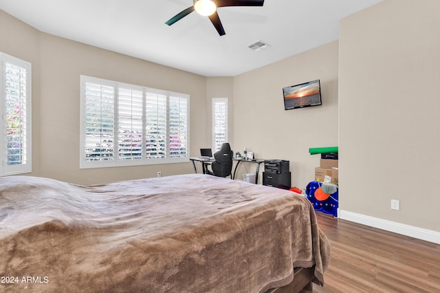 bedroom with multiple windows, ceiling fan, and hardwood / wood-style floors