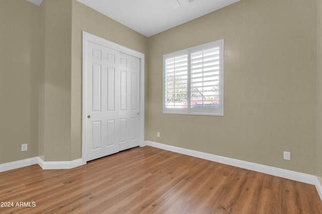 unfurnished bedroom with a closet and light hardwood / wood-style floors