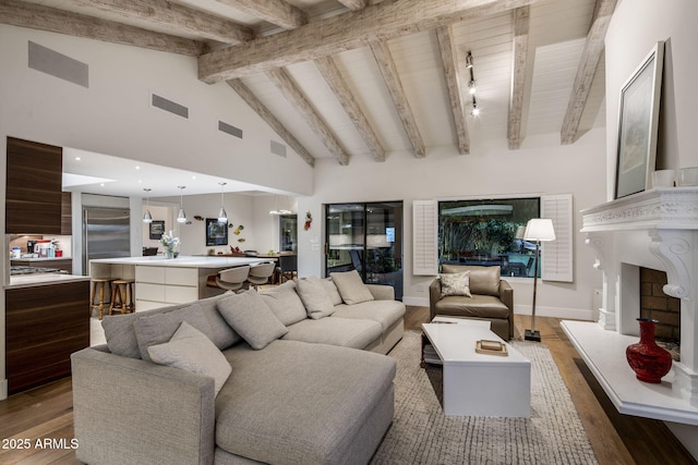 8312 N Golf Dr, Paradise Valley, AZ 85253 - living room featuring light wood-style floors, vaulted ceiling with beams, a fireplace with raised hearth, and visible vents