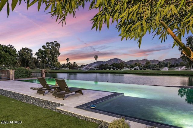 8312 N Golf Dr, Paradise Valley, AZ 85253 - pool at dusk featuring a patio and a water and mountain view