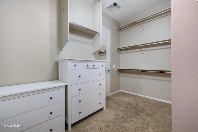 walk in closet with light carpet