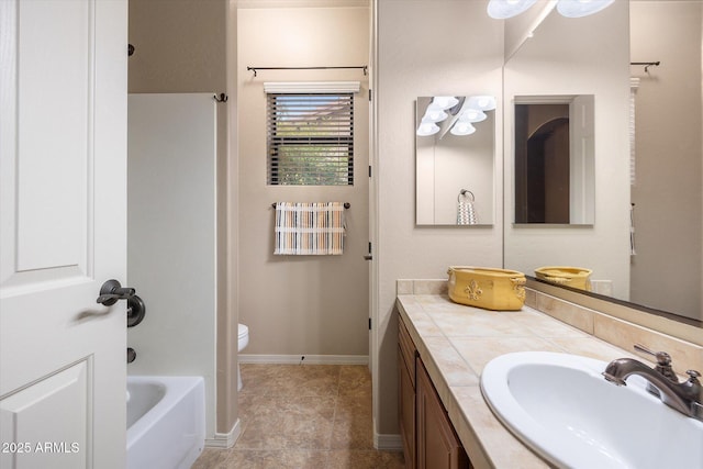 bathroom with vanity, a bath, and toilet