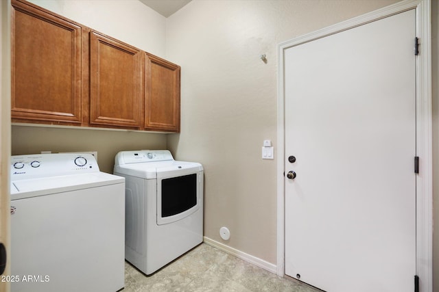 clothes washing area with washer and dryer and cabinets